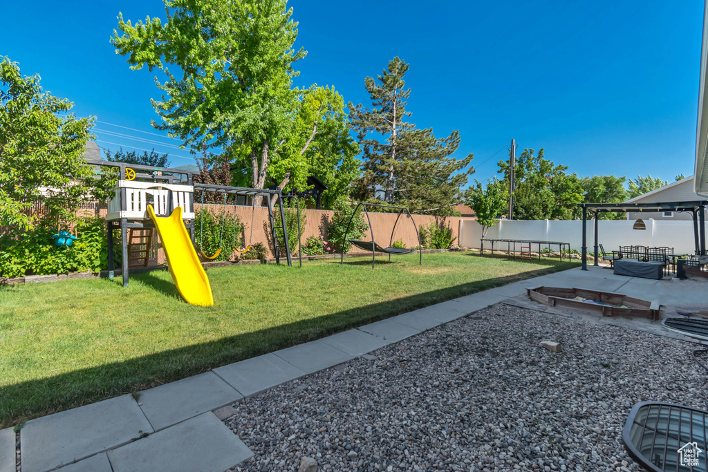 Fenced backyard with a playground and a patio