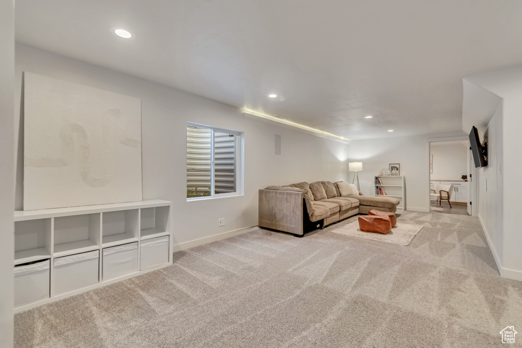 Carpeted living area featuring recessed lighting and baseboards