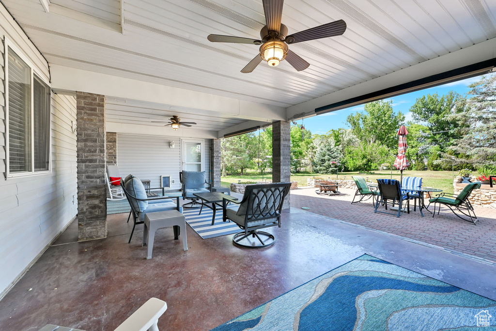 View of patio / terrace with ceiling fan, an outdoor living space with a fire pit, and outdoor dining area