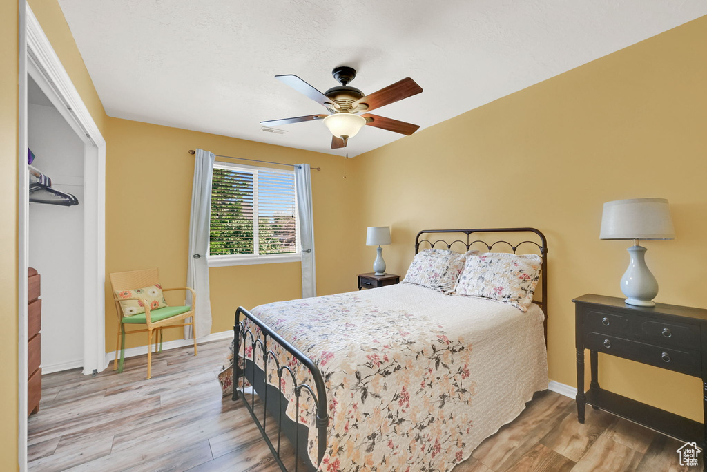 Bedroom with wood finished floors, a closet, and ceiling fan