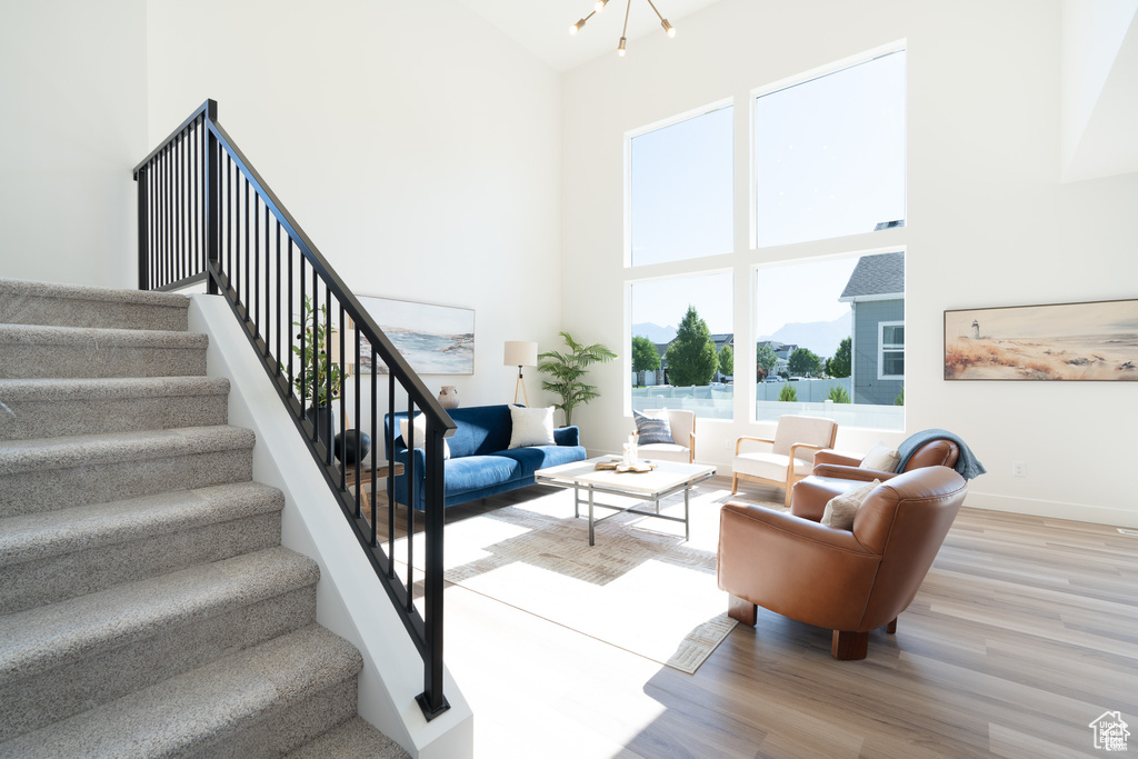 Living area featuring a high ceiling, wood finished floors, and stairway