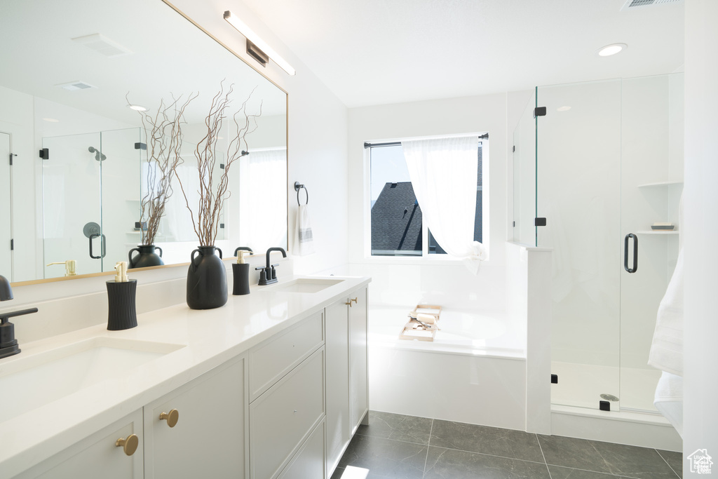 Full bath with a stall shower, a bath, and double vanity