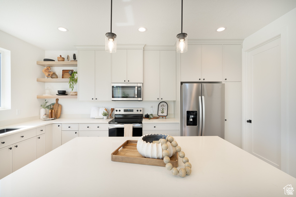 Kitchen featuring appliances with stainless steel finishes, open shelves, decorative light fixtures, light countertops, and recessed lighting