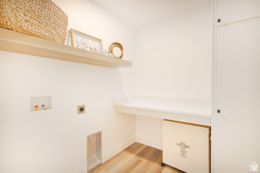 Washroom featuring electric dryer hookup, light wood-style flooring, and washer hookup
