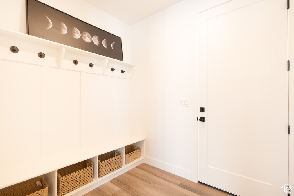 Mudroom with light wood finished floors and baseboards