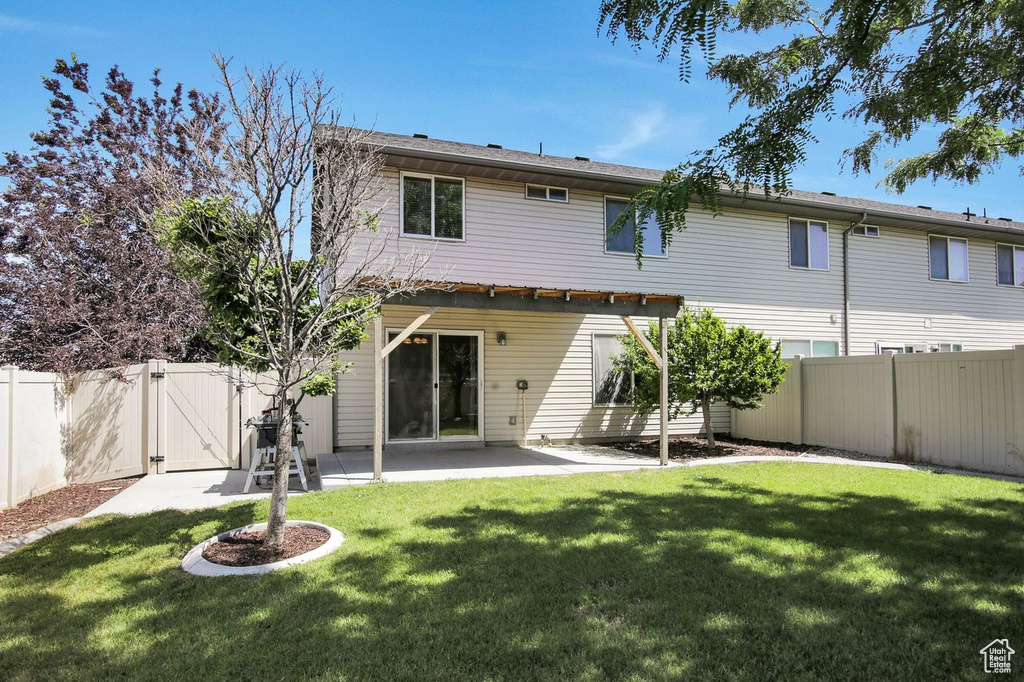 Back of house with a gate, a fenced backyard, and a patio