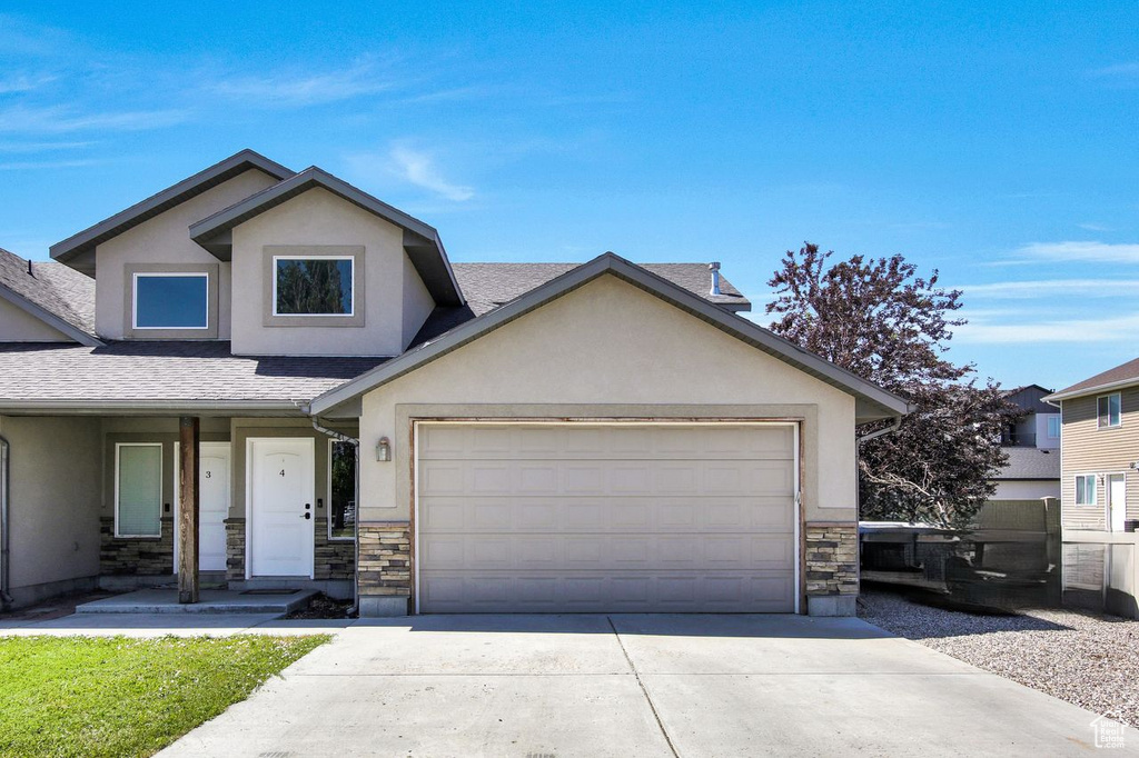 View of front of house featuring stucco siding, stone siding, concrete driveway, a shingled roof, and a garage
