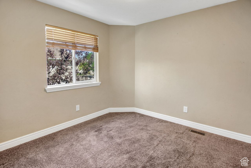Carpeted spare room with baseboards
