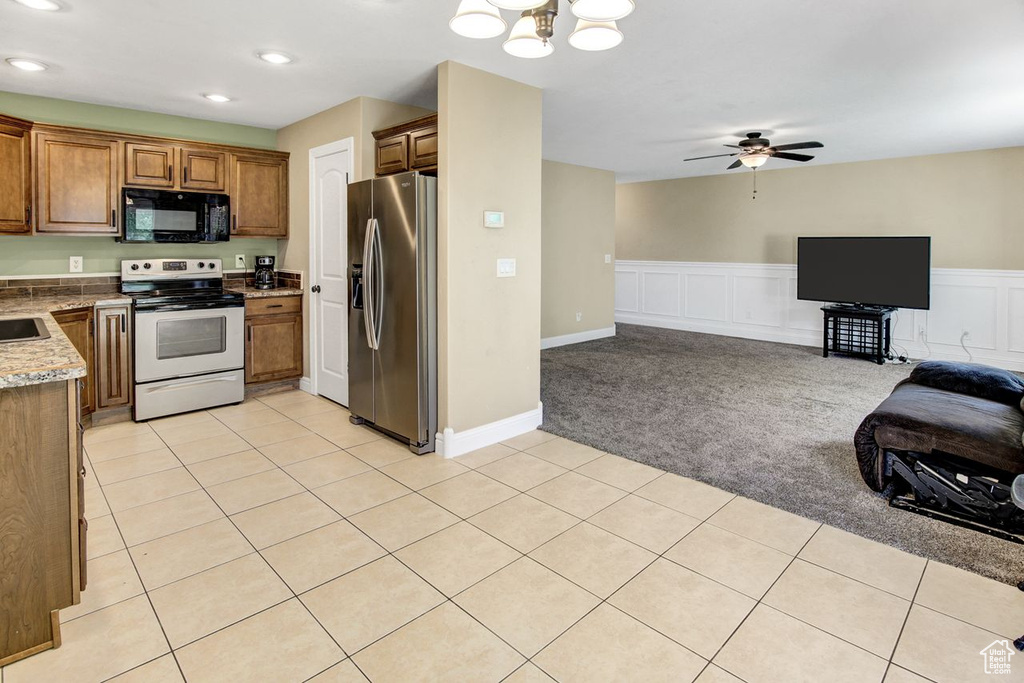 Kitchen with stainless steel fridge with ice dispenser, electric range, black microwave, open floor plan, and light colored carpet
