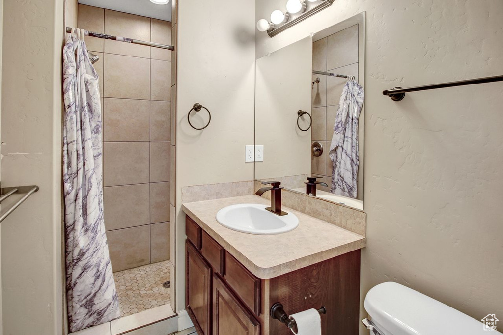 Bathroom with vanity and tiled shower
