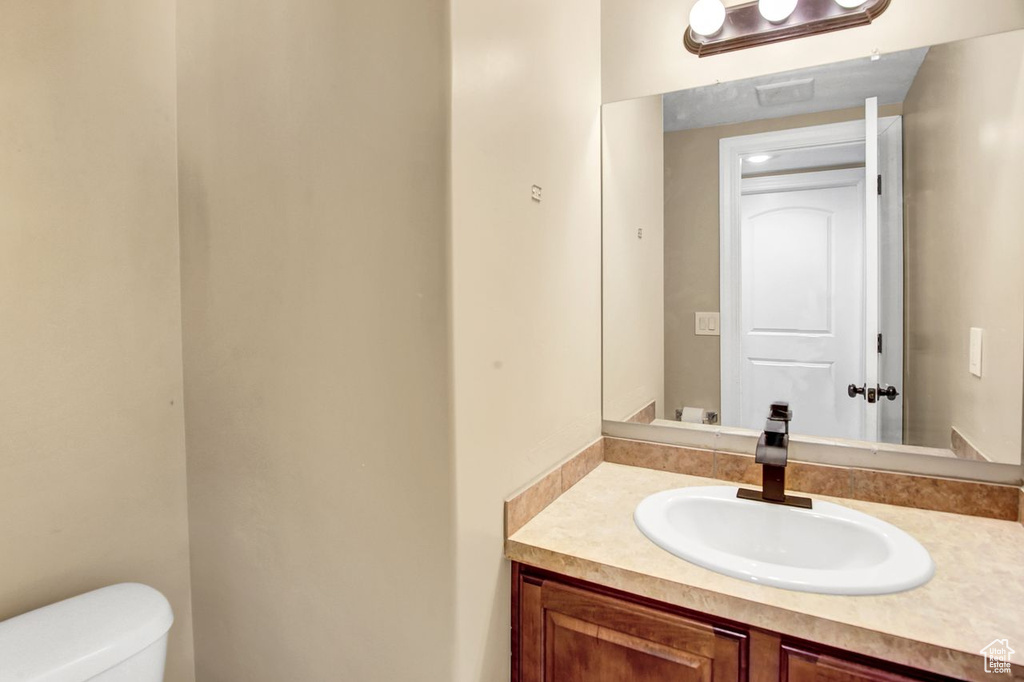 Half bathroom featuring vanity and toilet