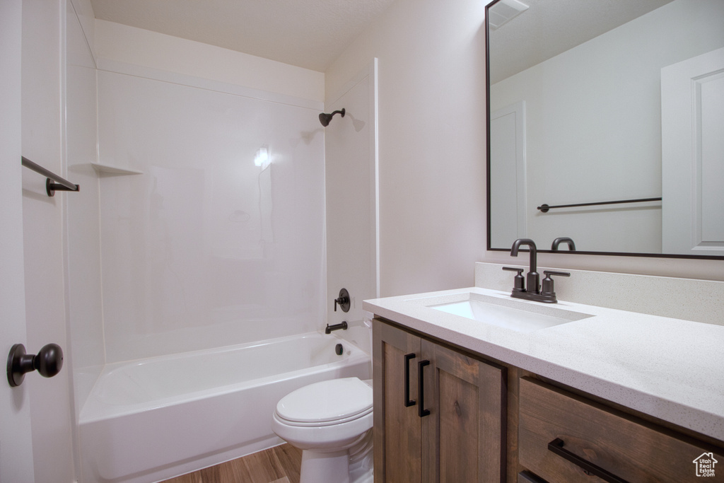 Bathroom featuring vanity, shower / bath combination, and wood finished floors