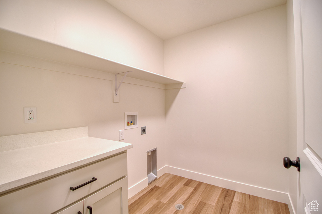 Washroom featuring electric dryer hookup, light wood-style flooring, and washer hookup