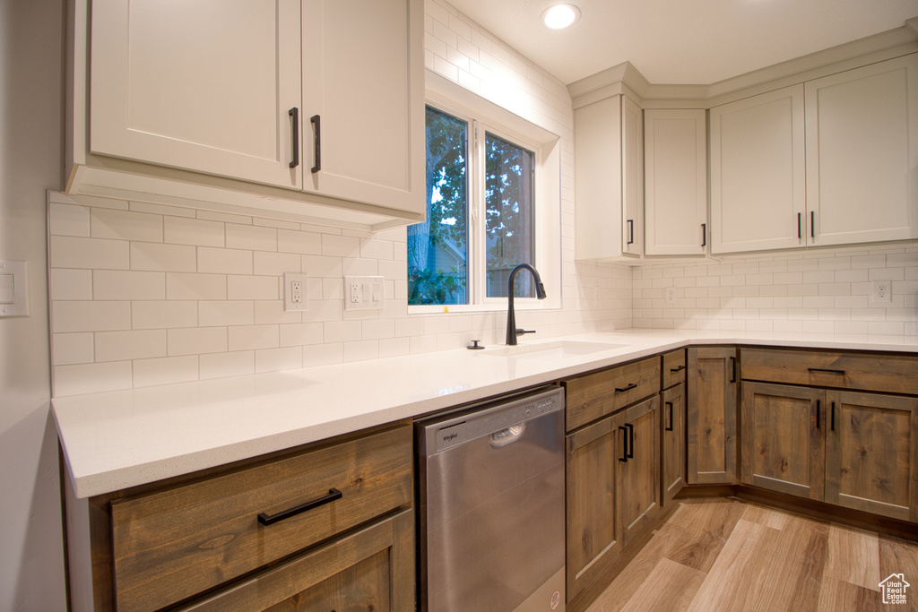 Kitchen with dishwasher, light wood-style flooring, decorative backsplash, light countertops, and recessed lighting