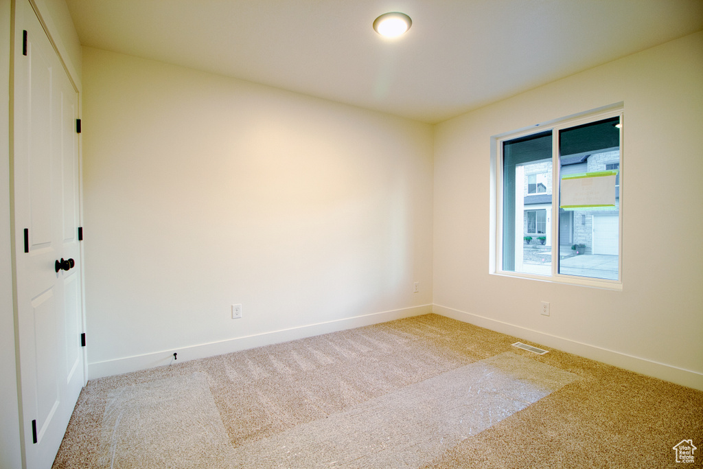 Carpeted empty room with baseboards