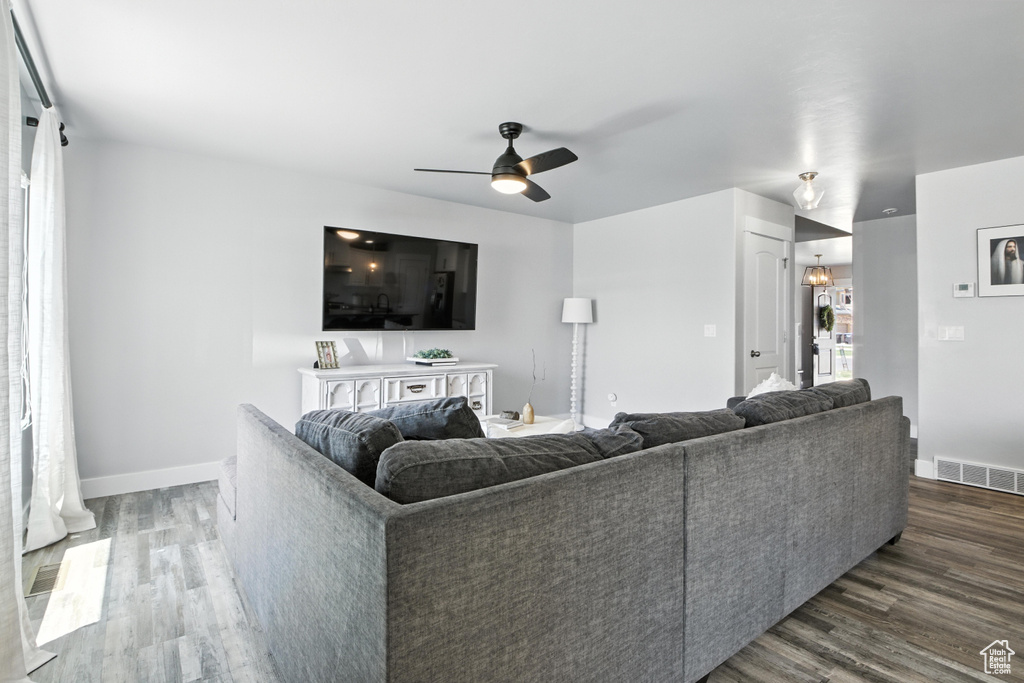 Living area with dark wood-type flooring and ceiling fan