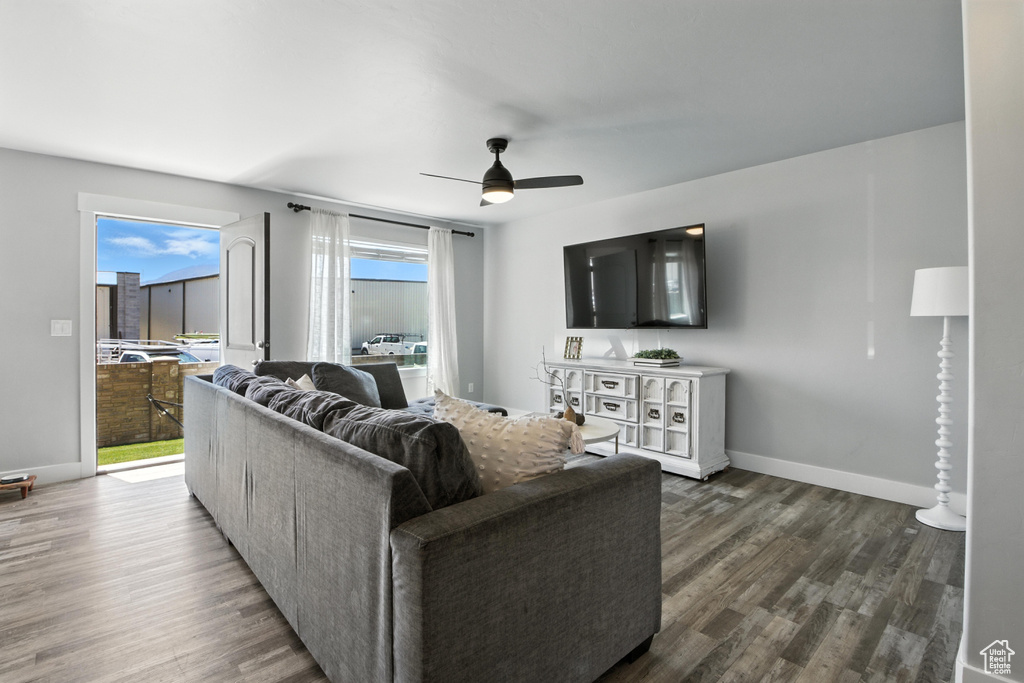 Living area with a ceiling fan and dark wood finished floors