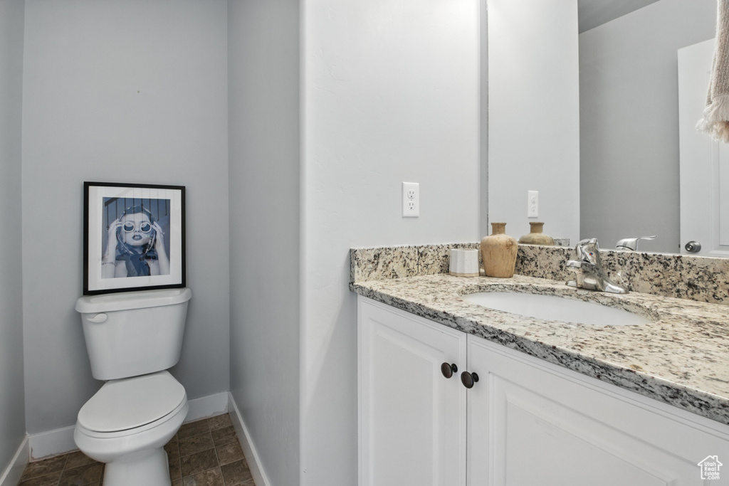 Half bath featuring vanity and baseboards
