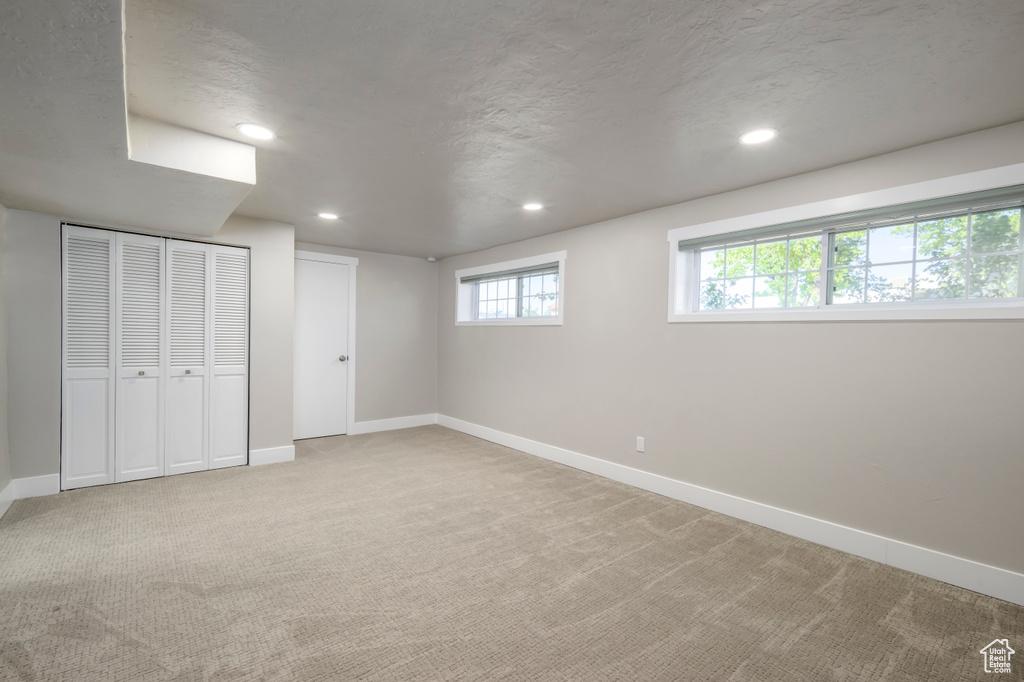 Unfurnished bedroom with light colored carpet and recessed lighting