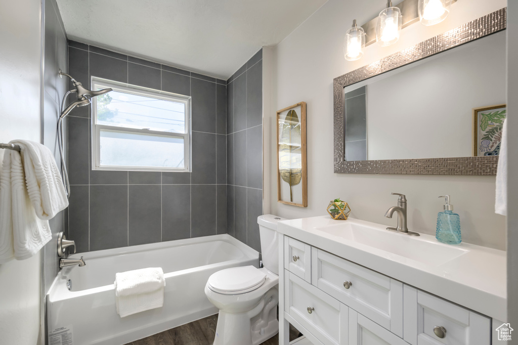 Bathroom featuring vanity, bathing tub / shower combination, and wood finished floors