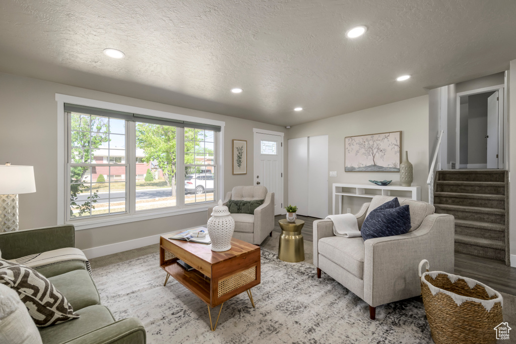 Living room featuring recessed lighting, a textured ceiling, and stairs