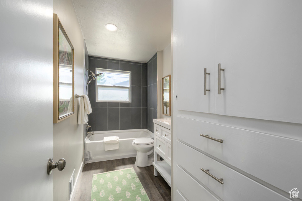 Full bath featuring wood finished floors, vanity, and tub / shower combination