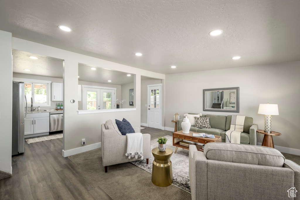 Living area with dark wood-type flooring, recessed lighting, and a textured ceiling