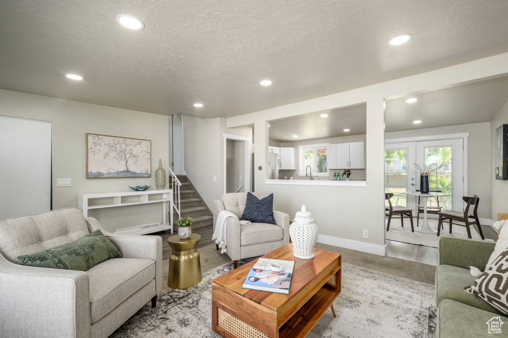 Living area with recessed lighting, a textured ceiling, and stairway