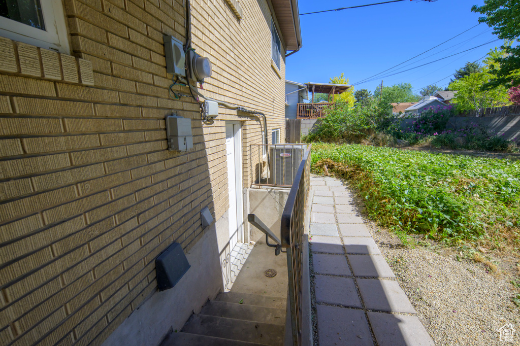View of side of home with brick siding and a central AC unit
