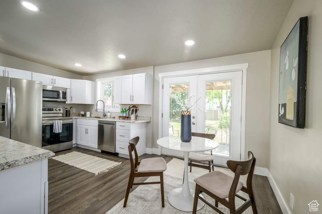 Kitchen with stainless steel appliances, dark wood-style floors, white cabinetry, french doors, and recessed lighting