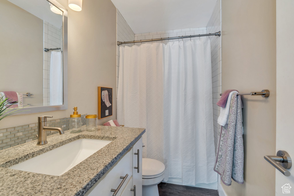 Full bath featuring vanity, a shower with curtain, and wood finished floors