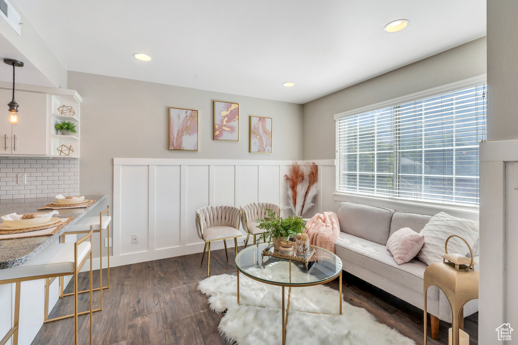 Living area featuring dark wood-style floors, recessed lighting, and a wainscoted wall