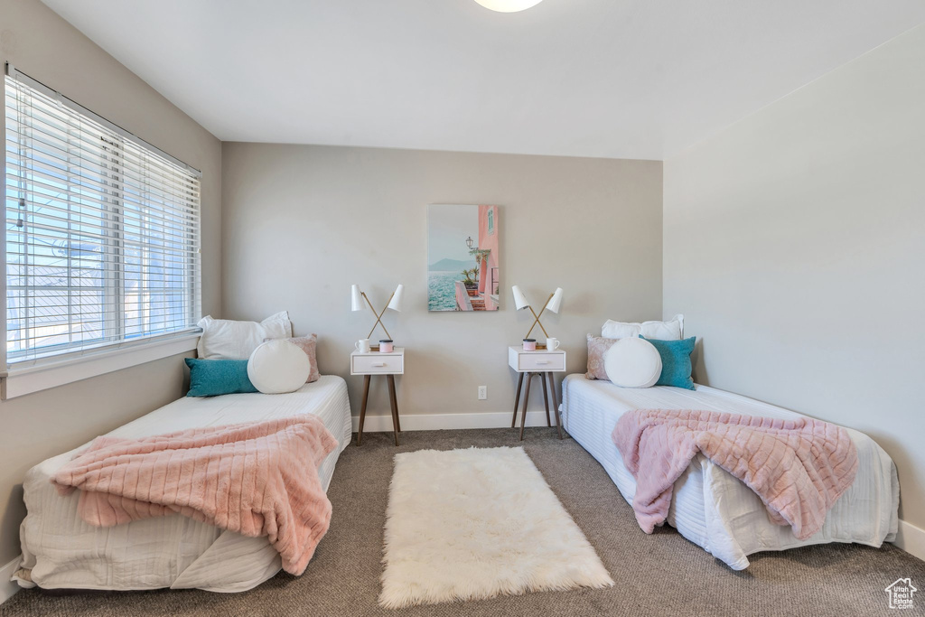 Bedroom featuring carpet and baseboards