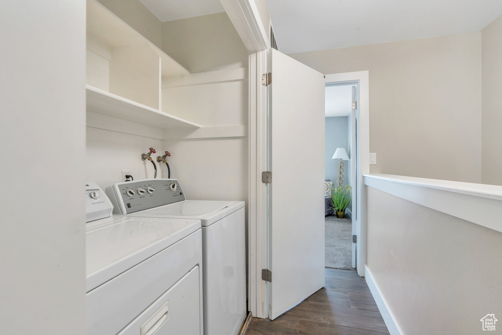 Washroom featuring washing machine and clothes dryer and dark wood-style flooring