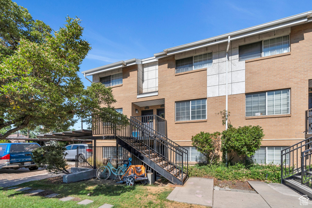 Rear view of property featuring stairs and brick siding