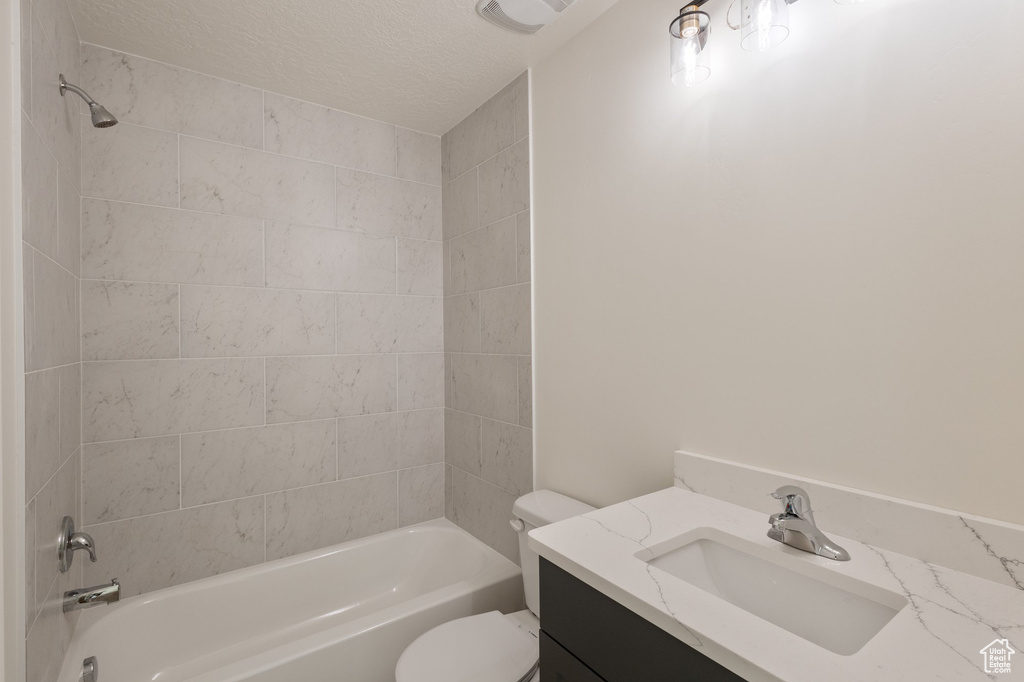Bathroom with shower / washtub combination, vanity, and a textured ceiling