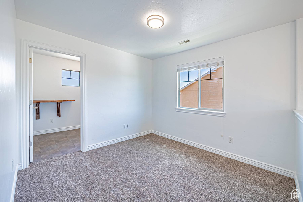 Empty room featuring carpet and plenty of natural light