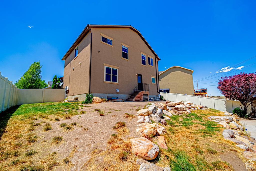 Rear view of property with a fenced backyard and stucco siding