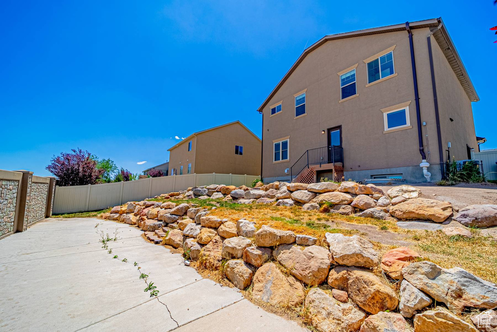 Rear view of house with stucco siding and a patio
