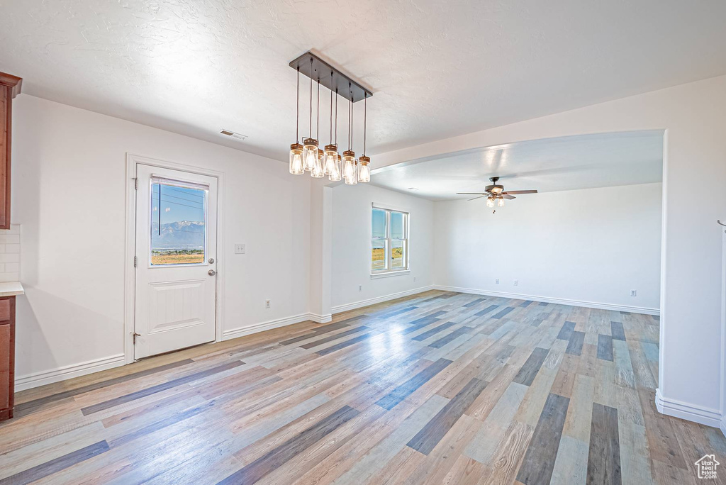 Unfurnished dining area featuring light wood-style floors and ceiling fan