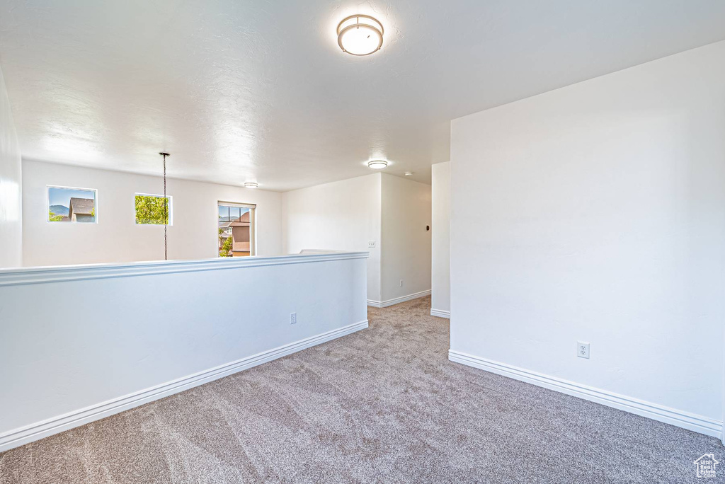 Spare room featuring carpet flooring and baseboards