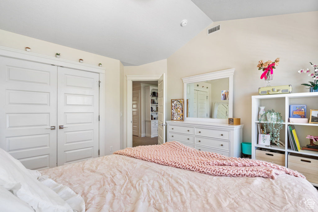 Bedroom with vaulted ceiling and a closet