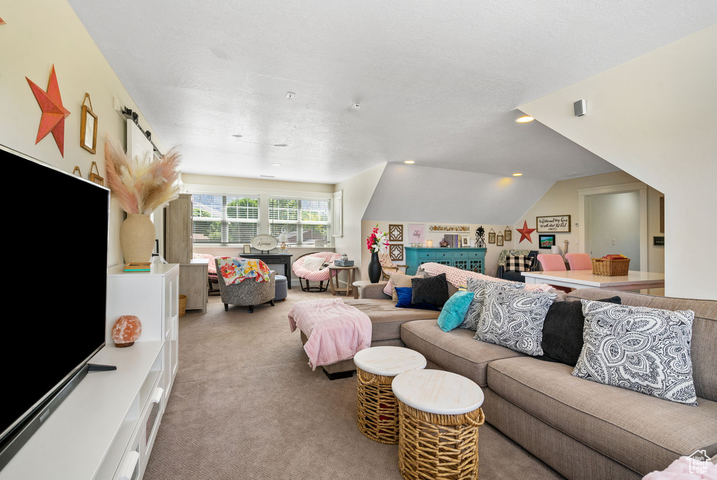 Carpeted living room featuring recessed lighting and vaulted ceiling