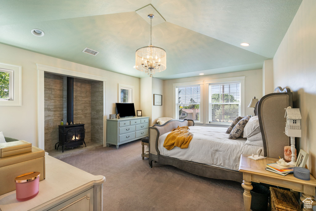 Bedroom featuring light colored carpet, a wood stove, a chandelier, and recessed lighting