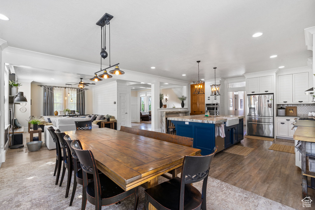 Dining area with dark wood-style floors, a ceiling fan, recessed lighting, and ornamental molding