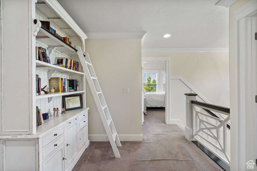 Corridor featuring carpet, crown molding, a textured ceiling, an upstairs landing, and recessed lighting