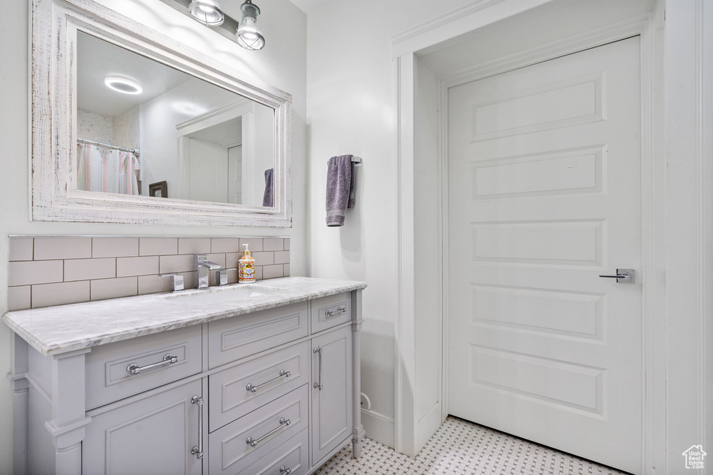 Bathroom with vanity, decorative backsplash, and tile patterned floors