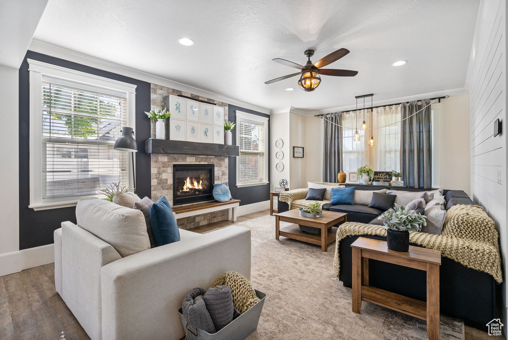 Living room with crown molding, a fireplace, ceiling fan, and recessed lighting