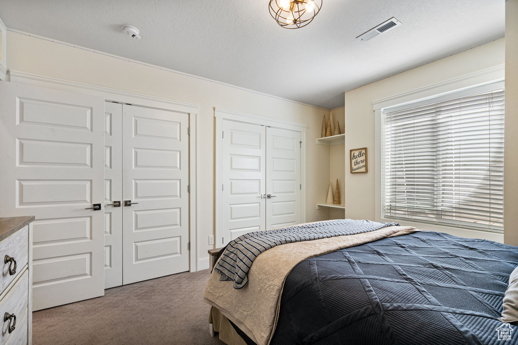 Bedroom featuring carpet flooring and two closets