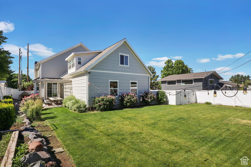 Rear view of house with a fenced backyard and a patio area